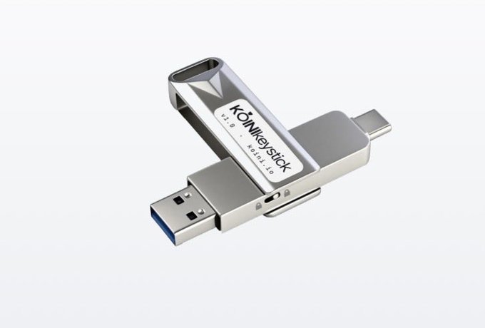 A silver and black "KÖNkeystick" USB flash drive with both USB-A and Type-C connectors on a gray background.