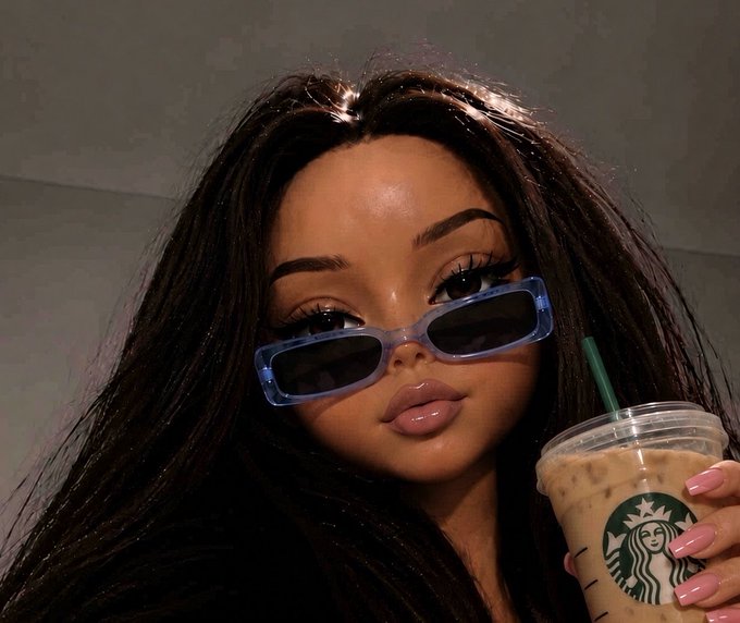 A woman wearing purple sunglasses poses while holding an iced Starbucks drink.