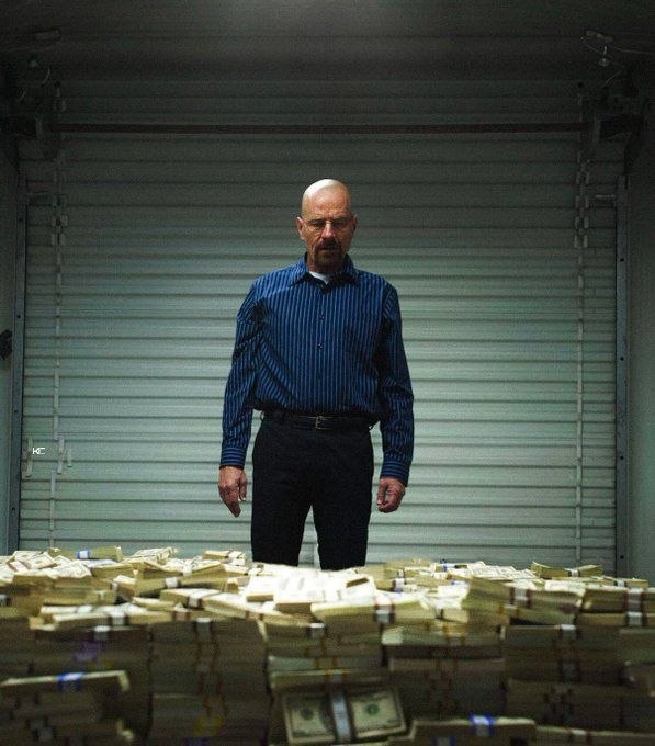 A bald man in a blue striped shirt stands solemnly in front of a massive pile of bundled cash in what appears to be a warehouse with a closed roll-up door behind him, visually reinforcing the meme's premise that the viewer has become a successful, wealthy trader.