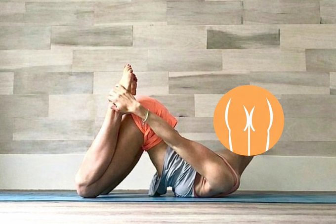 A person performing a yoga pose on a mat in a wood-floored room, with an orange circular logo overlaid on the right side.