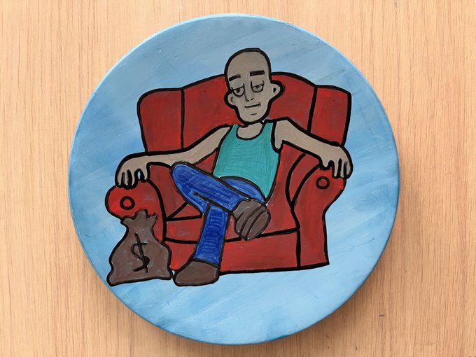 A hand-painted ceramic plate depicts a relaxed figure lounging in a red armchair next to a money bag marked with a dollar sign, set against a light blue background—visually bringing the MagicHood NFT project's signature chill, money-focused aesthetic into a tangible, handcrafted art piece.