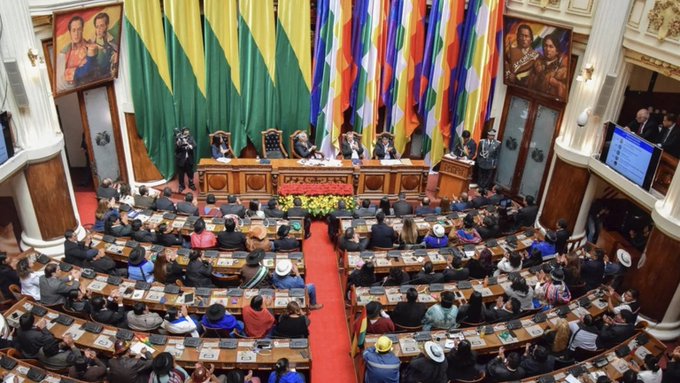 The image shows a session of Bolivia's Legislative Assembly, with lawmakers seated in a semicircular chamber surrounded by Bolivian flags and official portraits. It relates to the post by illustrating the governmental setting where discussions about integrating USDT into Bolivia's national payment system would take place.