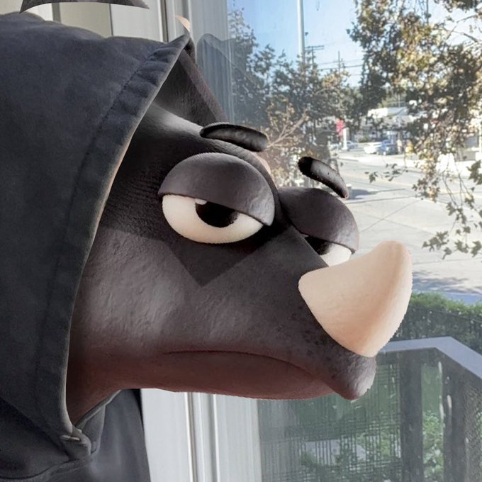 A person wearing a dark hooded sweatshirt poses outdoors with their face transformed by an AR filter that gives them a cartoonish, grumpy animal-like face with a large snout and droopy eyes.