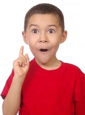 A young boy in a red t-shirt points upward with an excited, wide-eyed expression of surprise.
