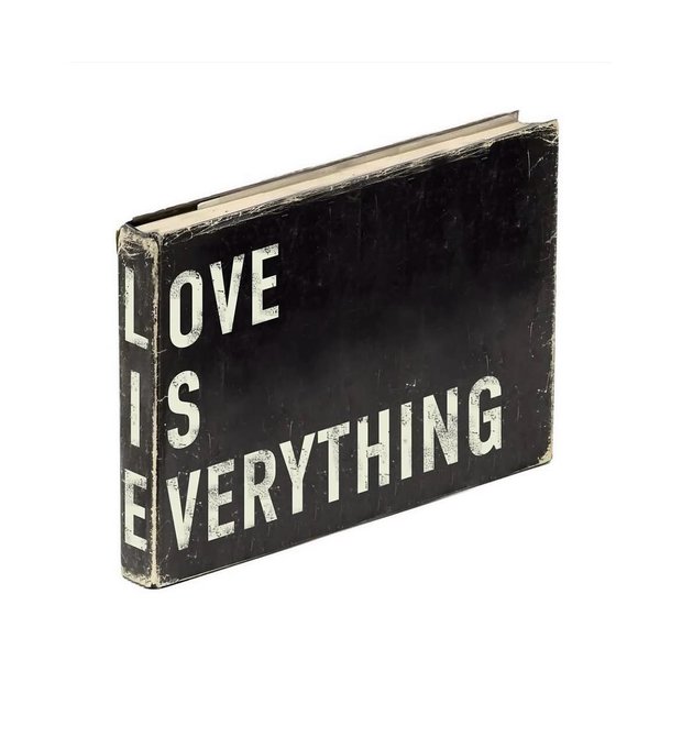 A worn black book with the text 'LOVE IS EVERYTHING' printed in white on its cover.