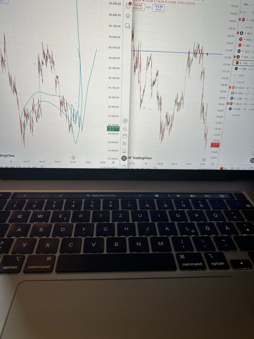 The image shows an open laptop computer with a screen displaying stock market data, including charts of Bitcoin prices over time. The laptop's keyboard is visible below the monitor, indicating that someone has been using the device for some time. The text on the screen reads "If u see dragons fighting coins go % 200% like …" and "Bitcoin $STRC had a lower low will moon hard for that now 86% my stomach feel finally". This suggests that the user is monitoring Bitcoin prices, possibly as part of their investment portfolio or financial analysis.