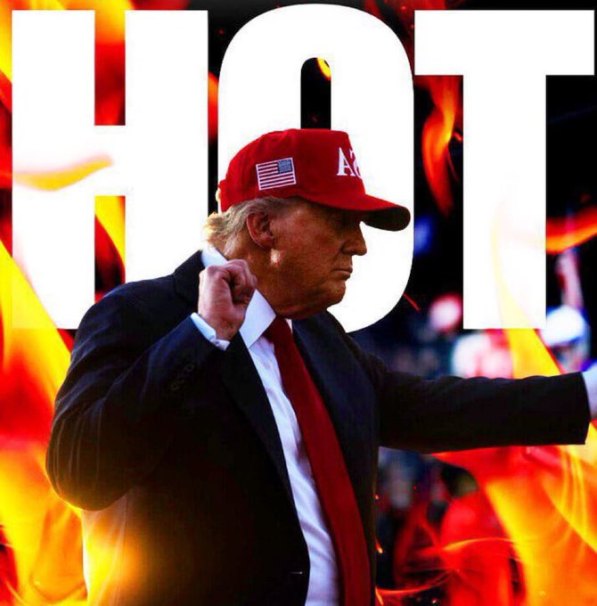 Donald Trump wearing a red cap with the American flag and the letters "AM" is shown raising his fist, set against a fiery background featuring the large white text "HOT" — visually evoking the "hot" exchange or rollout referenced in the post about the RV (redemption) and T5 already exchanging at banks in America.
