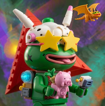 A quirky collectible toy figure featuring a green base character with star-shaped sunglasses, a white bunny-like helmet, red cape, holding a pink pig and a blue gun, with a small orange dragon figure flying nearby.