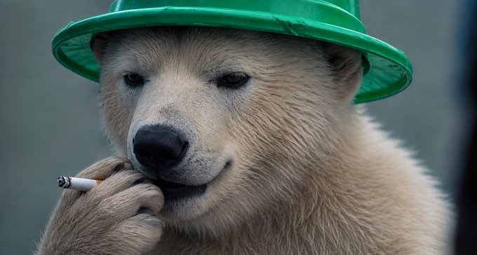 A white dog wearing a green plastic hat and holding a cigarette in its paw.