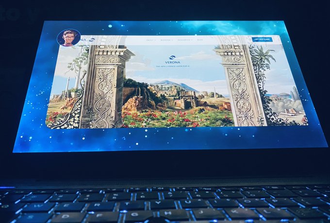 A laptop screen displays the "VERONA" website header, described as "THE NFT+USDC LIQUIDITY PLATFORM," featuring classical stone pillars framing a mountainous landscape.