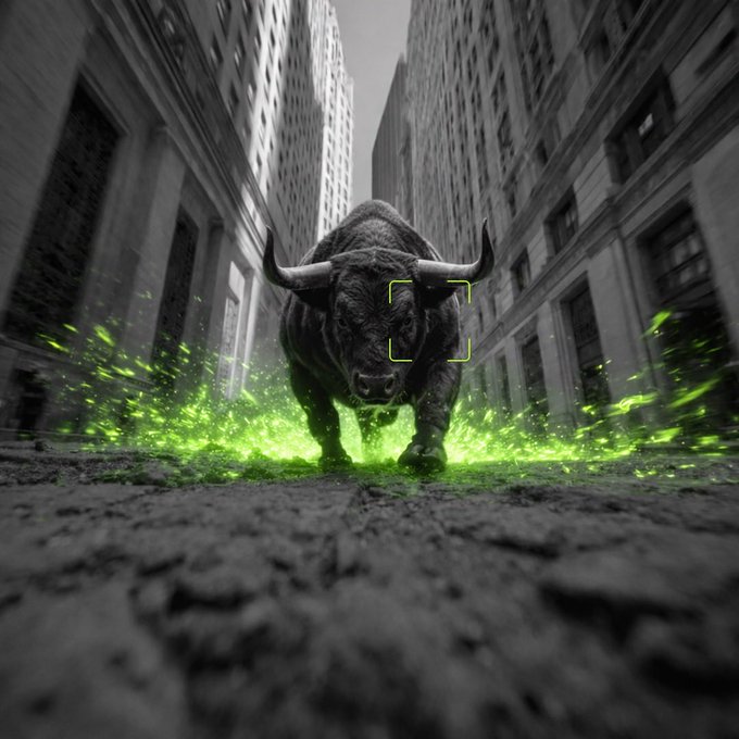 The image features a large, dark brown bull with horns running down an alleyway between two buildings. The bull appears to be charging forward or galloping along the street, creating a sense of motion and energy within the scene. In the background, there are several people scattered around the area, possibly observing the bull's progress or simply passing by.