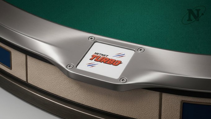 A close-up of a NetBet Turbo game table featuring a green felt surface, beige rails, and a central branded plaque with screws, along with an 'N' logo in the upper right.