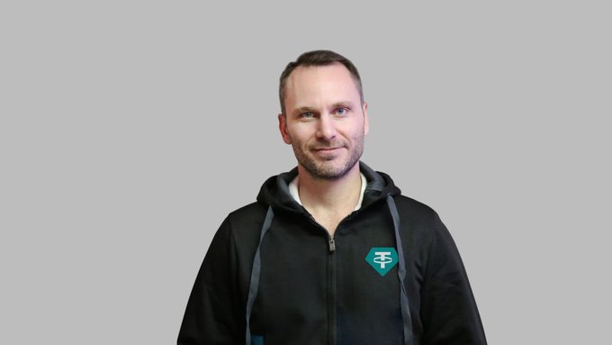 The image shows a man wearing a black hoodie with the Tether (₮) logo, appearing to be a representative or executive of the company. The caption connects to the post by visually representing the Tether brand behind the reported $1.5B Q2 profit, 146+ tons of gold holdings, and 650M+ USDT users milestone.