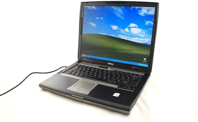 A Dell laptop displays the classic Windows XP "Bliss" desktop wallpaper, set against a white background. The post's reference to "Satoshi" and securing Bitcoin alludes to the early mining era, when the standard Windows XP operating system was commonly used to mine the first bitcoins.