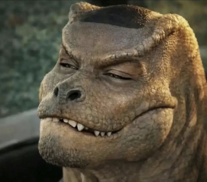 A close-up of a CGI dinosaur character with textured brown skin and visible teeth.