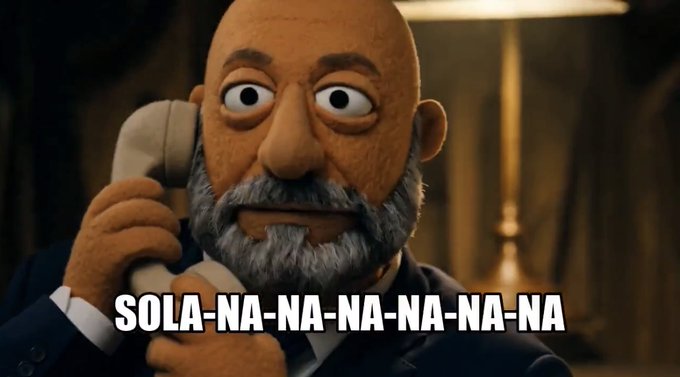 A claymation-style bald man with a gray beard holds a telephone to his ear with a focused expression, set against a dimly lit background with a lamp. Bold white text at the bottom reads "SOLA-NA-NA-NA-NA-NA," playfully spelling out "Solana" in the same rhythmic style as the classic "na-na" phone operator motif from movies like Die Hard, tying into the post's declaration about wanting Solana.