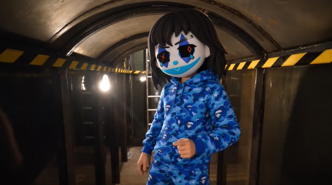 A video game character wearing a blue BAPE camo hoodie and a creepy, smiling mask in an industrial tunnel setting.