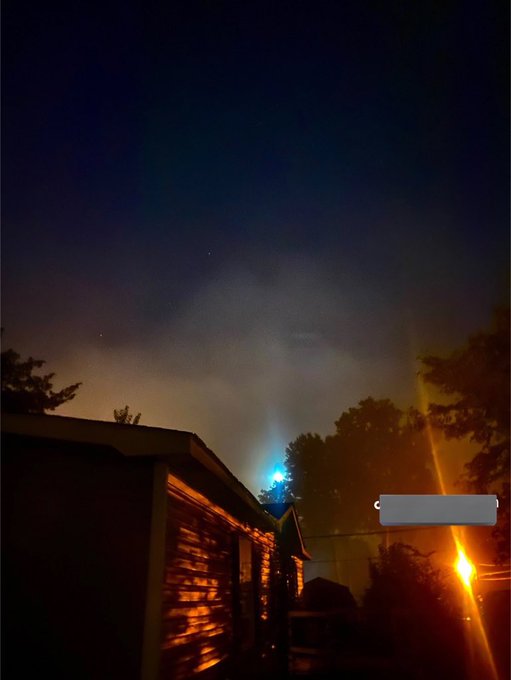 The image shows a house at night, with a street sign next to it that reads "Good night CT Nothing much to say, just grateful it ended not so bad, also, if you’re not aware, Mindo is cooking something with $Tria. Here’s my link app.tria.so/?accessCode=4B". The sky above the house has a dark blue color and appears cloudy.