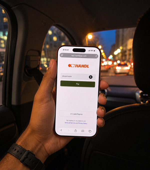 A person sits in the back of a car at dusk, holding a smartphone that displays the HandlPay login screen at app.handlpay.com. The image reinforces the post by demonstrating how a user can quickly share their @username on HandlPay to make receiving payments effortless.