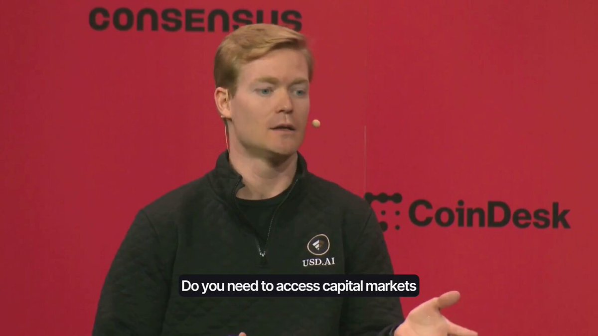The image features a man wearing a black jacket, standing against a red background with white text. The man appears to be giving a speech or presentation, as indicated by his body language and the fact that he has his hands out. The text on the image reads "Do you need access capital markets? @Consensus 2026 Miami." This suggests that the man is discussing the concept of accessing capital markets in relation to cryptocurrency, specifically mentioning the platform called Onchain Capital.
