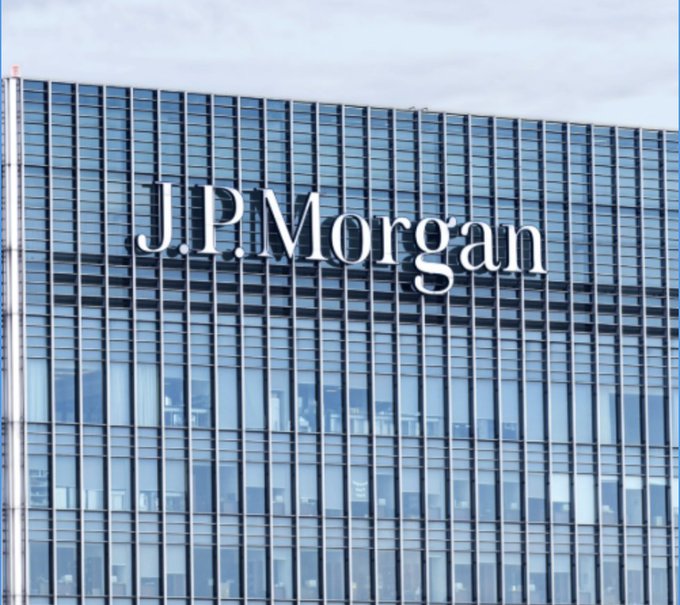 Exterior view of a modern glass office building displaying a large 'J.P. Morgan' sign on its facade.