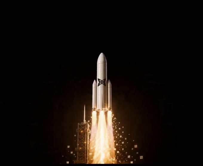 A white rocket with a butterfly logo launching at night with bright flames and sparks emerging from its engines.