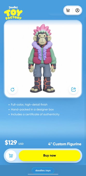 A mobile app screenshot for "Doodles Toy Factory" displaying a 4-inch custom figurine of a character with pink hair and a colorful vest, priced at $129 USD with a "Buy now" button.