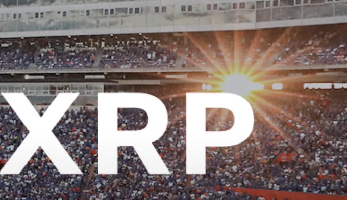 The bold "XRP" logo is overlaid on a packed stadium illuminated by bright sun flare, symbolizing a massive crowd's attention or hype surrounding the cryptocurrency. The image visually echoes the post's dreamlike vision of XRP achieving an extraordinary price equal to Bitcoin's, evoking the scale of spectacle and crowd energy that such a dramatic price shift would command.