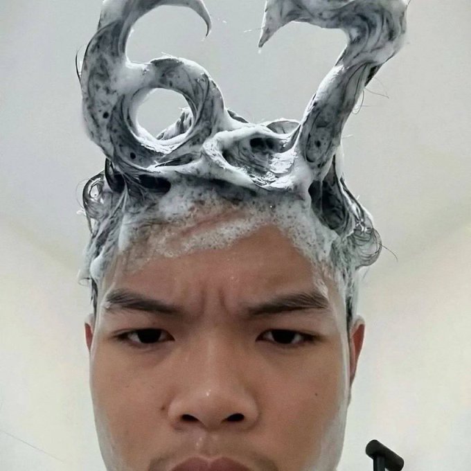 A young man takes a close-up selfie during a shower, with soapy suds swirled into horn-like shapes on top of his head, paired with a skeptical side-eye expression. The exaggerated "horns" metaphorically reinforce the post's warning about two types of token launches—those that flop ("devils") versus reliable ones like @sixsevenapp that keep delivering post-TGE.