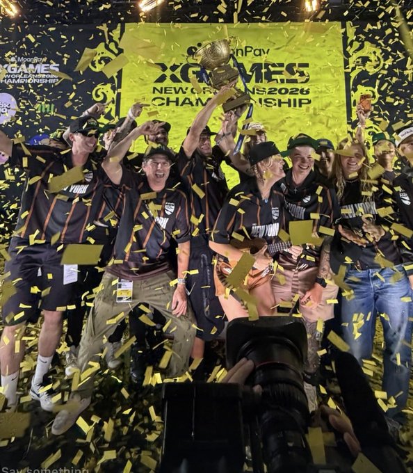 A celebratory photo of a Monopoly X Games Championship team holding up a trophy amid falling yellow confetti, with a banner reading 'X GAMES NEW ORLEANS 2025 CHAMPIONSHIP'.