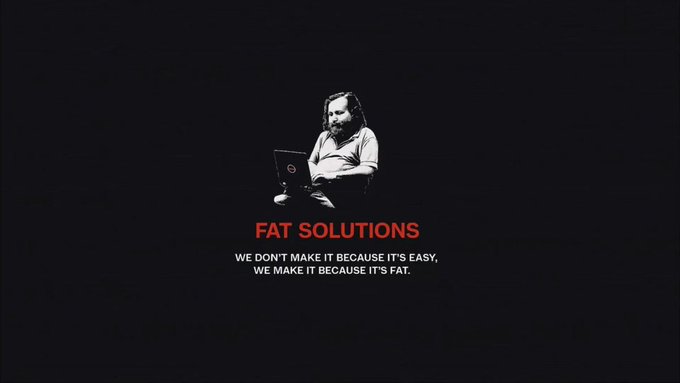 The image shows a man with long hair and a beard using a Dell laptop against a black background, with red and white text reading "FAT SOLUTIONS - WE DON'T MAKE IT BECAUSE IT'S EASY, WE MAKE IT BECAUSE IT'S FAT." 

The image relates to the accompanying post as a tongue-in-cheek visual metaphor for the cryptocurrency industry's struggles, with the man appearing contemplative or weary on his laptop—symbolizing how the company has persisted through difficult years despite crypto's stalled progress, while the "FAT SOLUTIONS" branding and defiant tagline suggest the announcement of bold, unconventional moves forward in a challenging market.