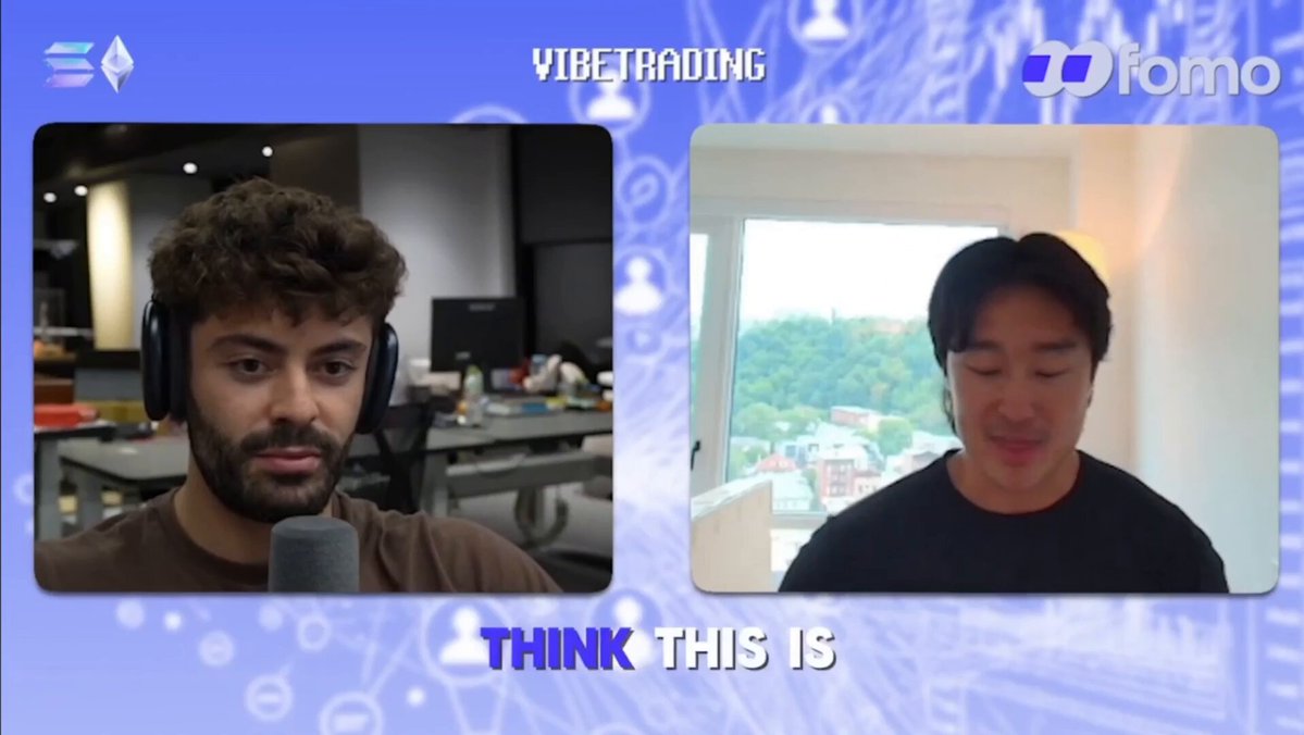 The image shows two men sitting at desks, with one man wearing headphones and the other not. They appear to be participating in an interview or discussion about a topic related to cryptocurrency. The background features a blue and white color scheme, which complements the content of the image.