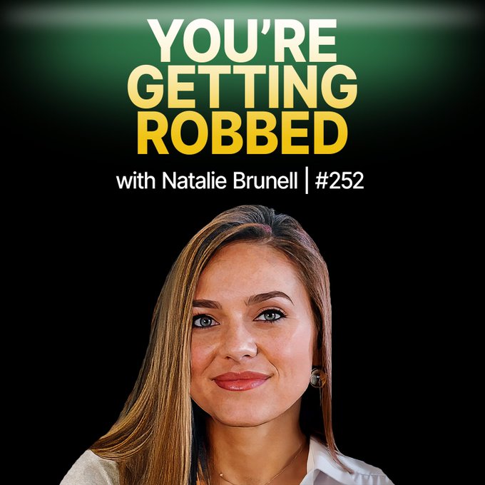 The image features a woman with long brown hair wearing a white shirt who appears to be smiling at the camera. The background of the image is black, which contrasts with her blonde hair. Above her head, there's text that reads "You're Getting Robbed", and below her head, there are numbers "252" and "# POWERS OF WISDOM". This suggests that she might be a host or an expert on Bitcoin, as indicated by the numbers above her head. The image seems to be related to the post about Natalie Brunell's views on Bitcoin, which is why it has been edited with this information.
