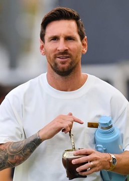 Lionel Messi is shown drinking from a traditional mate cup, appearing relaxed. The image relates to a Polymarket bet of $318k wagering on Messi not scoring two or more goals in the World Cup final.