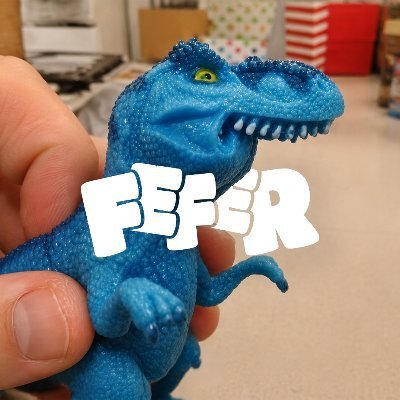 A hand holds a blue, glittery plastic toy dinosaur, with the text 'FEFER' overlaid in large white letters.