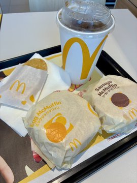 McDonald's meal on a tray with two wrapped Egg McMuffin-style sandwiches and a Coca-Cola drink.