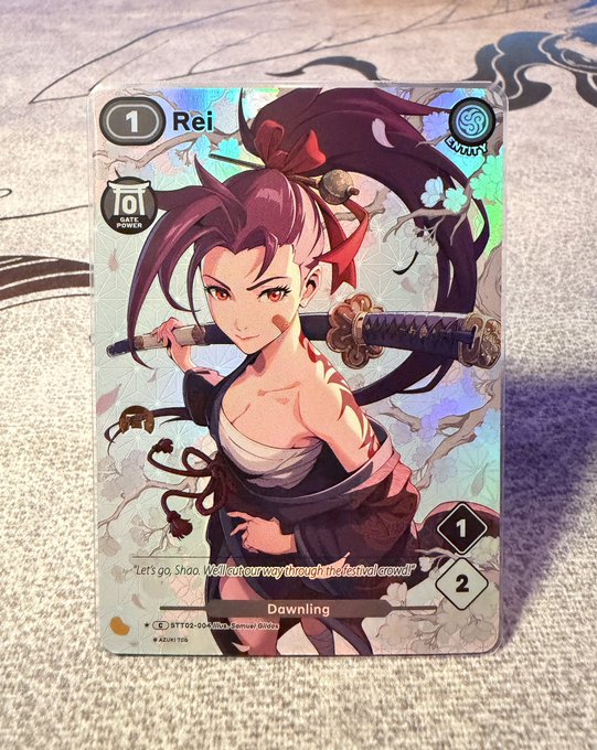 A holographic trading card featuring "Rei" in an alternate art design, marked with a cost of 1, gate power of 10, and labeled "Dawning" with the card number ST/02-065. The card depicts the character with a sword and includes the dialogue "Let's go, Sho. We'll cut our way through the festival crowd!" connecting to the post about this rare Garden Sentinel exclusive Rei card being showcased ahead of the Azuki manga release.