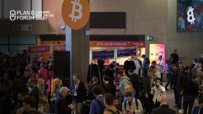 A crowded conference hall for the "PLAN B LUGANO FORUM 2025" featuring large Bitcoin logos and cryptocurrency-themed signage including "CYPHERPUNK" and "Peer Tickets".