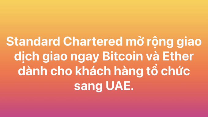 A gradient orange-pink banner with white Vietnamese text reading 'Standard Chartered mở rộng giao dịch giao ngay Bitcoin và Ether dành cho khách hàng tổ chức sang UAE,' announcing Standard Chartered's expansion of spot Bitcoin and Ether trading for institutional clients to the UAE.