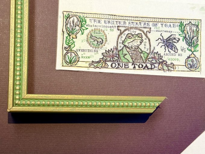 An artistic $1 US bill where Benjamin Franklin's portrait has been replaced by a frog, and the text reads 'THE UNITED STATES OF TOADS', 'BREAD FOR EVERYTHING', 'PAY MY TAXES', and 'AROUND ME 420596'.