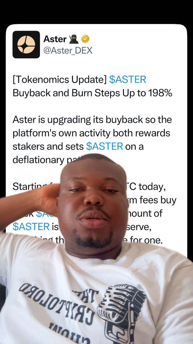 The image shows a man wearing a white t-shirt with a black design, sitting down and looking at his phone screen. The text displayed on the screen reads "Aster 2 update $ASTER buyback & Burn steps up to 1998". This information is related to the post about the price of Aster 2 in the comments section.