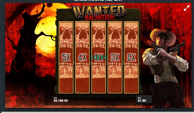 A "Wanted Dead or a Wild" slot machine game screen showing a bonus round labeled "SALVATION" with skull symbols at multipliers of 5X, 4X, 3X, 2X, and 1X, displaying a win of $5,180.00 from a $1.80 bet. The image captures a base game spin on Stake, as indicated by the caption, featuring the game's signature Western-themed imagery with a masked gunslinger against a red moon backdrop.