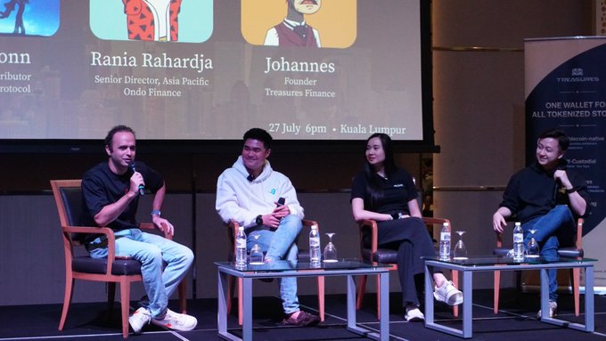 Four panelists, including Rania Rahardja (Senior Director, Asia Pacific, Ondo Finance) and Johannes (Founder, Treasures Finance), sit on stage at the Treasures Finance event on 27 July in Kuala Lumpur, with the speaker engaging the audience by having his agent distribute a $HOOD tokenized RWA prize on the big screen.