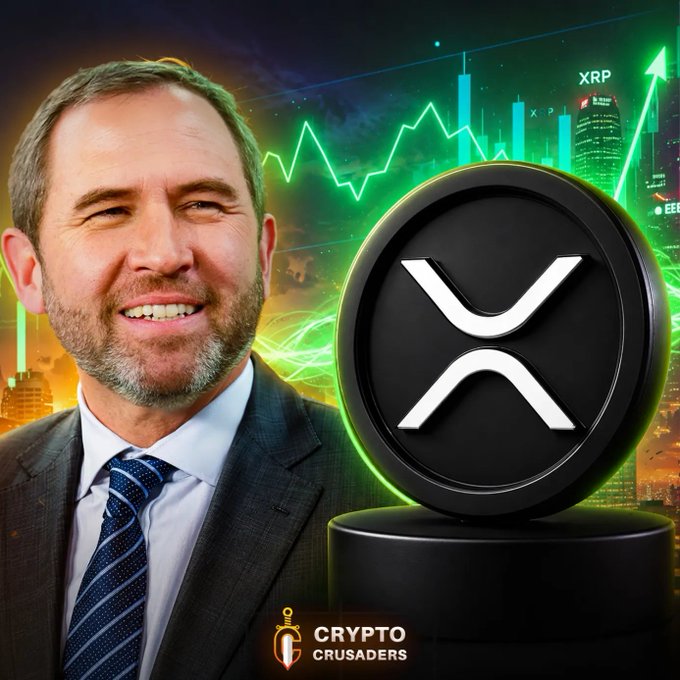 The image features a man wearing a suit, standing next to a black coin with an XRP symbol on it. The background of the image shows a city skyline at night, which adds depth and context to the scene. The caption below the image reads "The Greatest $XRP Explanation In History In Under 9 Minutes crusadersnewsletter.com/p/the-greatest …"