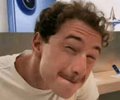 The image shows a man with curly hair grinning mischievously while wearing a white shirt, conveying a sly or smug expression. This aligns with the playful post "BP is pumping $BP," using the man's cheeky grin to humorously suggest British Petroleum's stock is being artificially boosted.