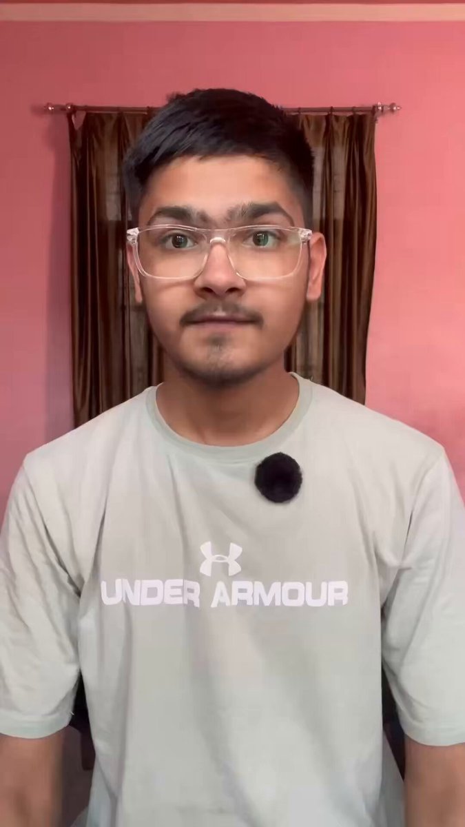 A man wearing glasses, a grey T-shirt with white Under Armour logo and a black ball cap stands next to a pink wall against which he poses for the camera. The room where the photo was taken features some curtains and a mirror that add depth to the image. There is no discernible text in this image apart from the man's description of the coinbase and circle deal, which explains how Hyper Liquid might generate an additional $150M-200M annually through buybacks or burns.