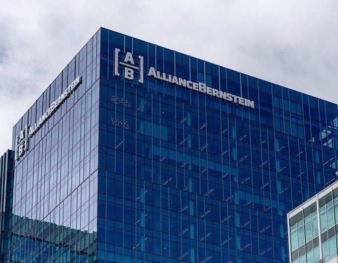 A photograph of the AllianceBernstein (AB) office building, featuring a blue glass facade with the company's logo and name prominently displayed.