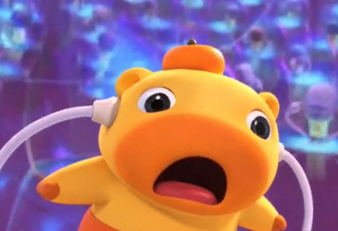 An animated yellow bear-like character wearing a jetpack looks shocked with its mouth open against a purple background.