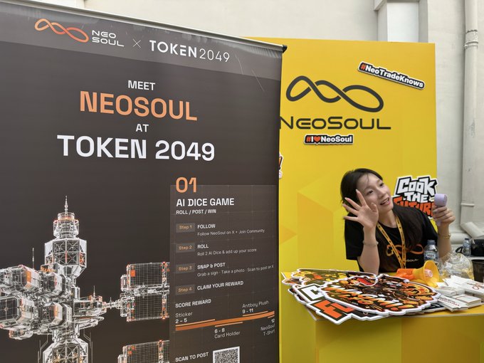 A woman poses with a peace sign at the vibrant yellow NeoSoul booth at TOKEN 2049, where signage promotes an "AI Dice Game" with the steps to "Roll / Post / Win" for a chance at an "Anthony Plush" reward. The image directly ties to the caption's mention of rolling the AI Dice with @NeoSoulAI at the event, showcasing the promotional setup for the crypto giveaway.