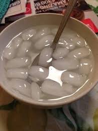 A bowl of tang yuan (glutinous rice balls) in clear broth, with chopsticks resting inside, posted alongside a giveaway asking users to retweet and send a Solana (SOL) wallet address to enter the drawing.